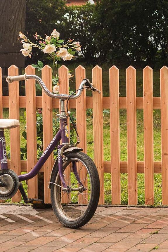 Kinderfahrrad vor Gartenzaun